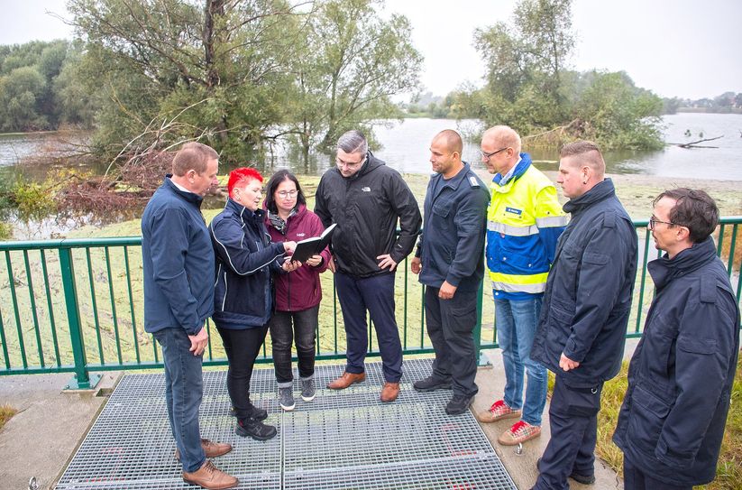 Am neuen Siel in Mühlberg (v.l.n.r.): Landrat Christian Jaschinski, die Bürgermeisterin der Verbandsgemeinde Liebenwerda, Claudia Sieber, Gundula Manigk, Leiterin des Bauamtes der Verbandsgemeinde, Maximilian Schöne, Bürgermeister Mühlberg, Andy Selig, Mühlbergs stellvertr. Ortsgemeindewehrführer, Marco Hanke, Leiter des Ordnungsamtes des LKEE, Martin Neumann, stellvertr. Verbandsgemeindewehrführer, Mathias Bauer, Verbandsgemeindewehrführer.