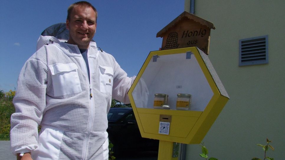 Daniel Neubauer am stationären Verkaufsstand vor seinem Haus. Vor allem die Bewohner des Arnsdorfer Neubaugebietes, wo der 34-Jährige seit zwei Jahren wohnt, schätzen seinen Honig, hier hat er die meisten Abnehmer für seinen Honig.