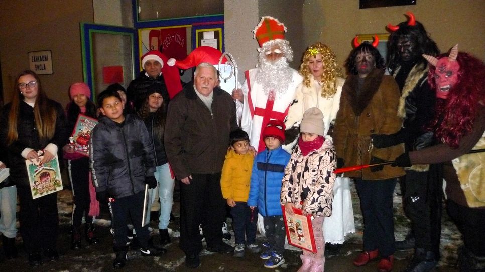 Klaus Fiedler inmitten der Kinder und der Nikolausabordnung - rechts die Teufel - vor dem Eingang zum Roma-Zentrum.