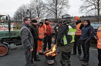 Teilnehmer wärmen sich bei um die minus 8 Grad am Feuer.