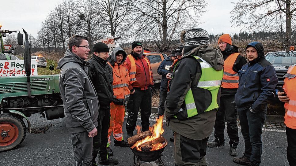 Teilnehmer wärmen sich bei um die minus 8 Grad am Feuer.