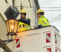 Mitarbeiter der Meißener Stadtwerke setzen die erste neue Leuchte in der Burgstraße ein.  Die Lichtfarben sind sehr ähnlich.