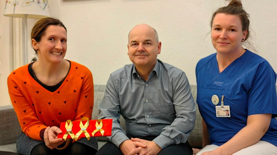 Ulrike Grundmann, Leiterin psychosoziales Team, mit den ersten goldenen Schleifen - auch für Prof. Ralf Knöfler und Antje Berg, Stationsleiterin in der Kinderonkologie.