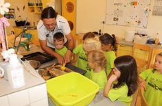 Blick in die Kita »Regenbogen«: Bevor die Honigwaben in die Schleuder kommen, muss die Wachsschicht mit einer Entdeckelungsgabel entfernt werden. Das macht hier Erzieher Jörg Reinhold gemeinsam mit Kindern im Experimentierraum.