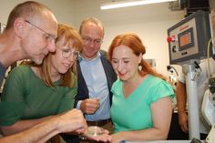 Ein NOMOS-Mitarbeiter zeigt Justizministerin Katja Meier, Energieminister Wolfram Günther und der Landtagsabgeordneten Franziska Schubert (Grüne) (v.l.n.r) Zahnräder für die Herstellung von NOMOS-Uhren.
