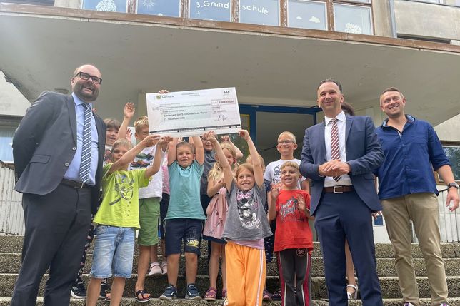 Kultusminister Christian Piwarz überbringt den symbolischen Scheck über 9,96 Millionen Euro für die Sanierung und den Umbau der 3. Grundschule in Weida.