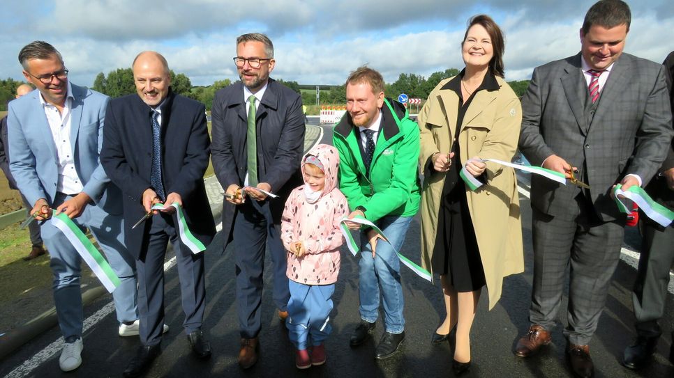 Der Erste Beigeordnete des Landkreises Bautzen, Jörg Szewczyk, der Bürgermeister der Gemeinde Lichtenberg, Thomas Wuttke, Verkehrsminister Martin Dulig, Ministerpräsident Michael Kretschmer, die Präsidentin des Landesamtes für Straßenbau und Verkehr, Dr. Saskia Tietje, und der Radeberger Oberbürgermeister Frank Höhme haben die junge Generation in ihre Mitte genommen und eröffnen gemeinsam die Ortsumgehungsstraße bei Leppersdorf. Foto: Matthias Stark