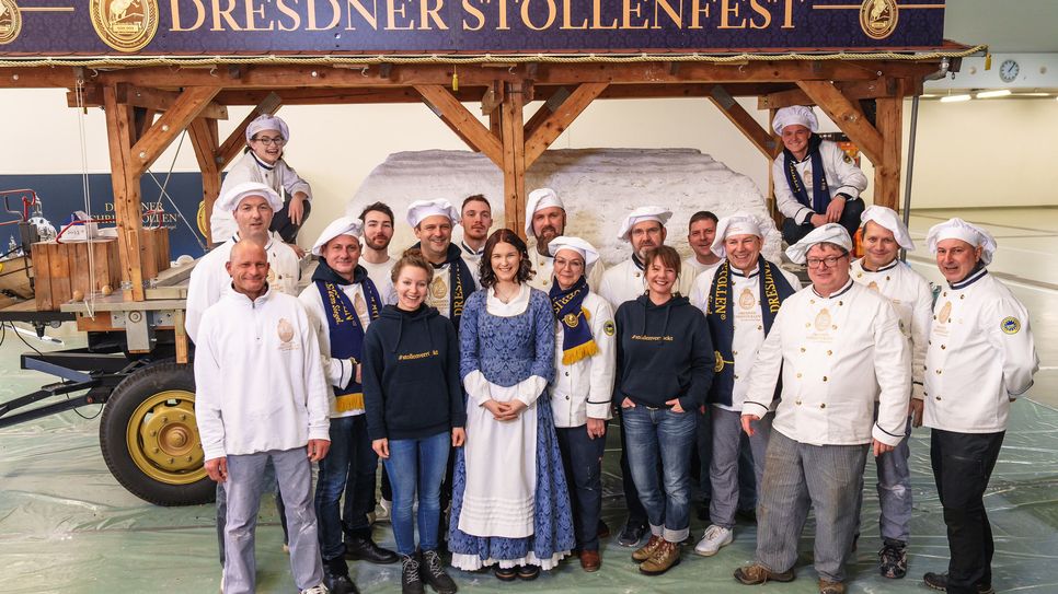 Das Riesenstollen-Team und Stollenmädchen Nelly Köhler präsentieren stolz den fertigen Riesenstollen - zum Stollenfest am 9. Dezember wird er Stückweise für den guten Zweck verkauft.