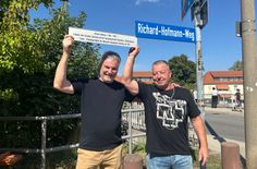 Oberbürgermeister Uwe Rumberg (li.) mit Hofmann-Enkel Lutz Herrmann beim Anbringen der Zusatztafel am Straßenschild.