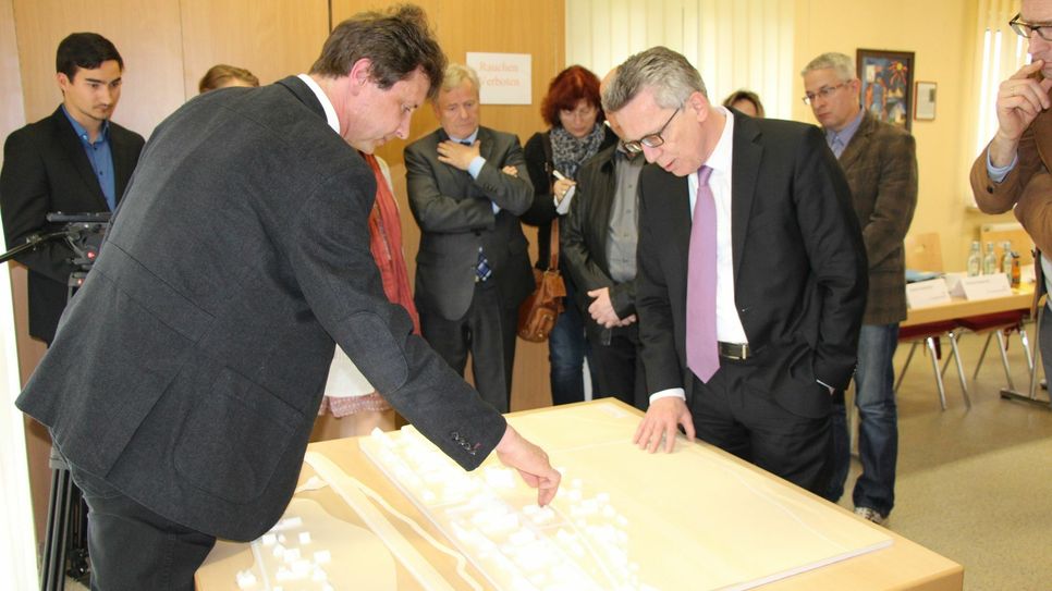 Ein Modell der Haushebung für die Häuser auf der Niederseite von Brockwitz zum Schutz vor Elbhochwasser gibt es schon. Dr. Thomas de Maizière (CDU) (re.) bekommt die Möglichkeiten der Haushebung von Olaf Lier (li.), Stadt Coswig, erläutert. Foto: Lindackers