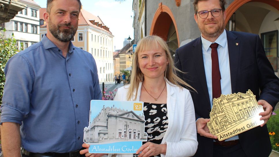 Kulturservice-Prokurist Gerd Weise, Kulturservice- Geschäftsführerin Maria Schulz und Bürgermeister Benedikt M. Hummel präsentieren das Motiv des Altstadtfest-Pins 2023.