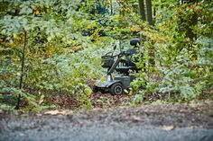 Der Elektrorollstuhl steht einsam im Wald. Foto: M. Förster