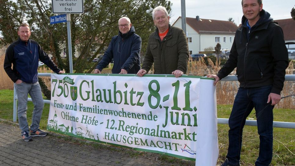 Das Banner zu 750 Jahre Glaubitz hängt. Martin Reichstädter von der Feuerwehr, Lutz Härtel vom Sportverein Einheit Glaubitz, Lutz Thiemig, Bürgermeister, und Martin Rettig vom Kulturverein (v.l.) freuen sich, dass das erste Banner hängt.